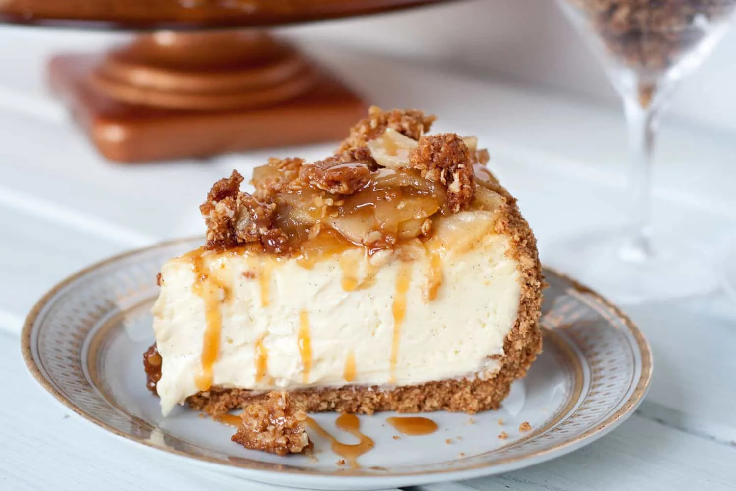 Caramel Apple Cheesecake - A creamy vanilla bean cheesecake on a cinnamon graham crust topped with a homemade apple pie filling, a crunchy streusel topping, and liberally drizzled with caramel sauce! Get the recipe on GoodieGodmother.com