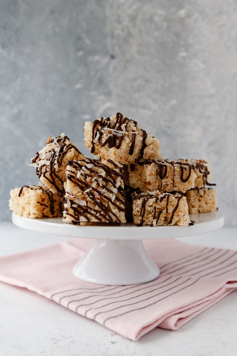 coconut rice cereal treats stacked on a cake plate