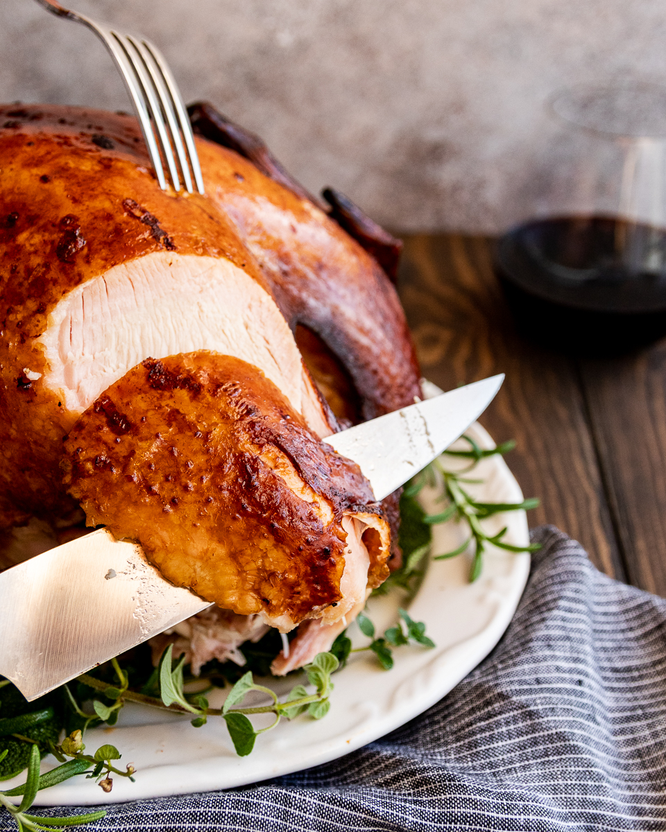 thanksgiving turkey being sliced to highlight the juiciness of the breast meat using this turkey brine recipe 
