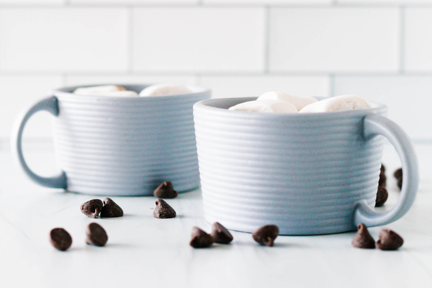 horizontal image of the two hot chocolate mugs prepared using this small batch hot chocolate recipe for two (or one)
