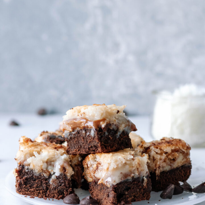 dulce de leche coconut brownies stacked on a white plate