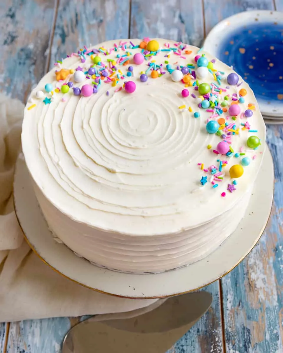 Naturally white, and easy to mix up with no special ingredients required, this white cake recipe from scratch is moist and delicious! Put down the box mix, and make white cake from scratch at home. * Recipe on GoodieGodmother.com #whitecake #weddingcake #birthdaycake #vanillacake