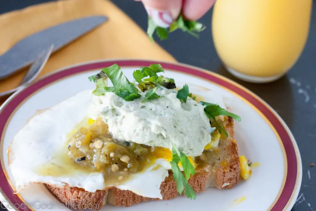 Savory avocado whipped cream tops an open face breakfast sandwich that looks (and tastes) like it came from your trendy neighborhood bistro! Recipe on GoodieGodmother.com