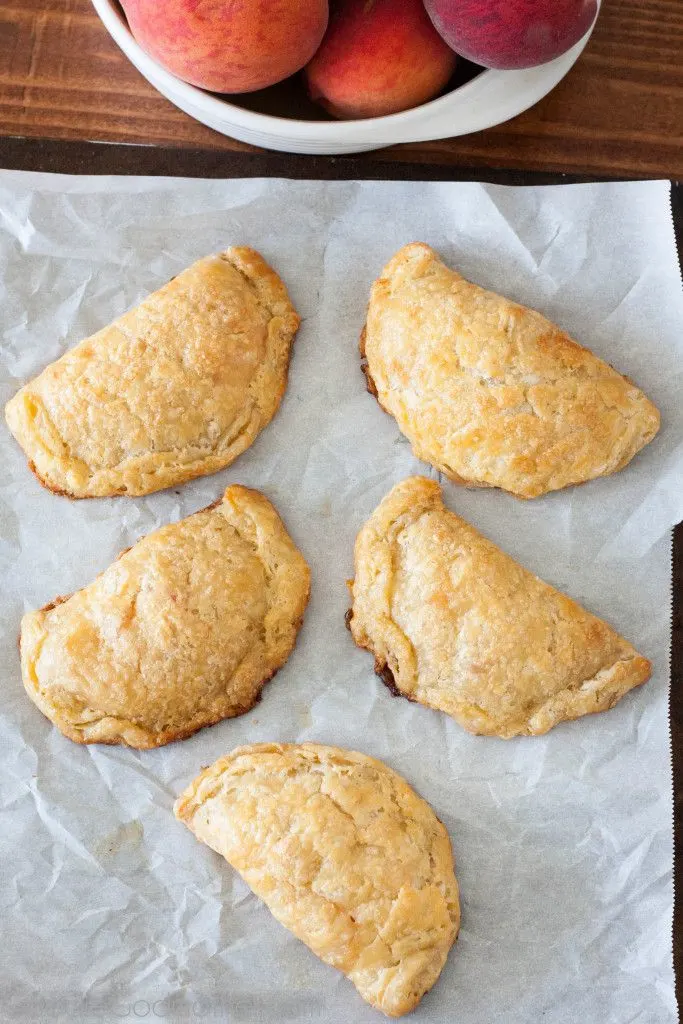 Summer peaches make a perfect filling for flaky peach hand pies with an all butter crust. Recipe on GoodieGodmother.com