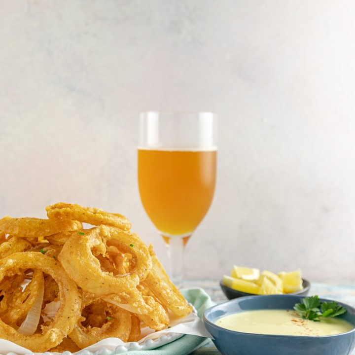 Beer Battered Old Bay Onion Rings with Creamy Lemon Dipping Sauce - An appetizer or side dish that's boardwalk ready, no matter where you are!