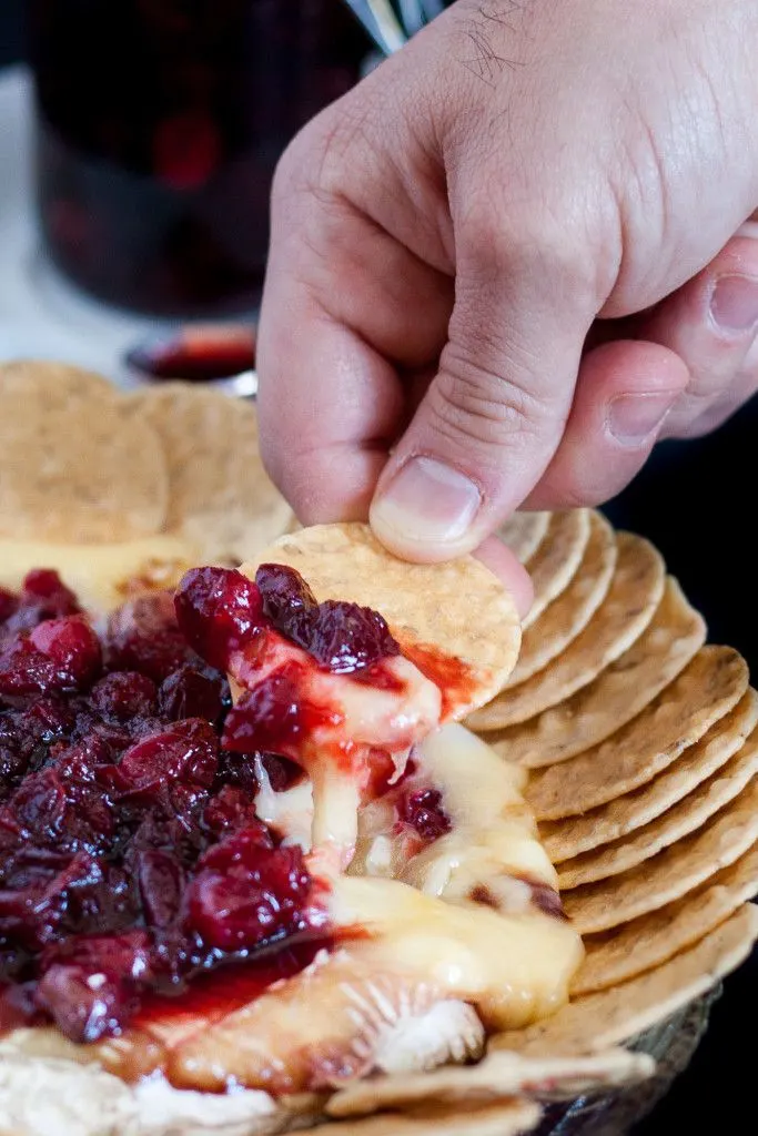 Baked brie is an impressive, yet easy holiday appetizer! This recipe tops the baked brie with a fresh cranberry balsamic compote that keeps you coming back for bite after bite!