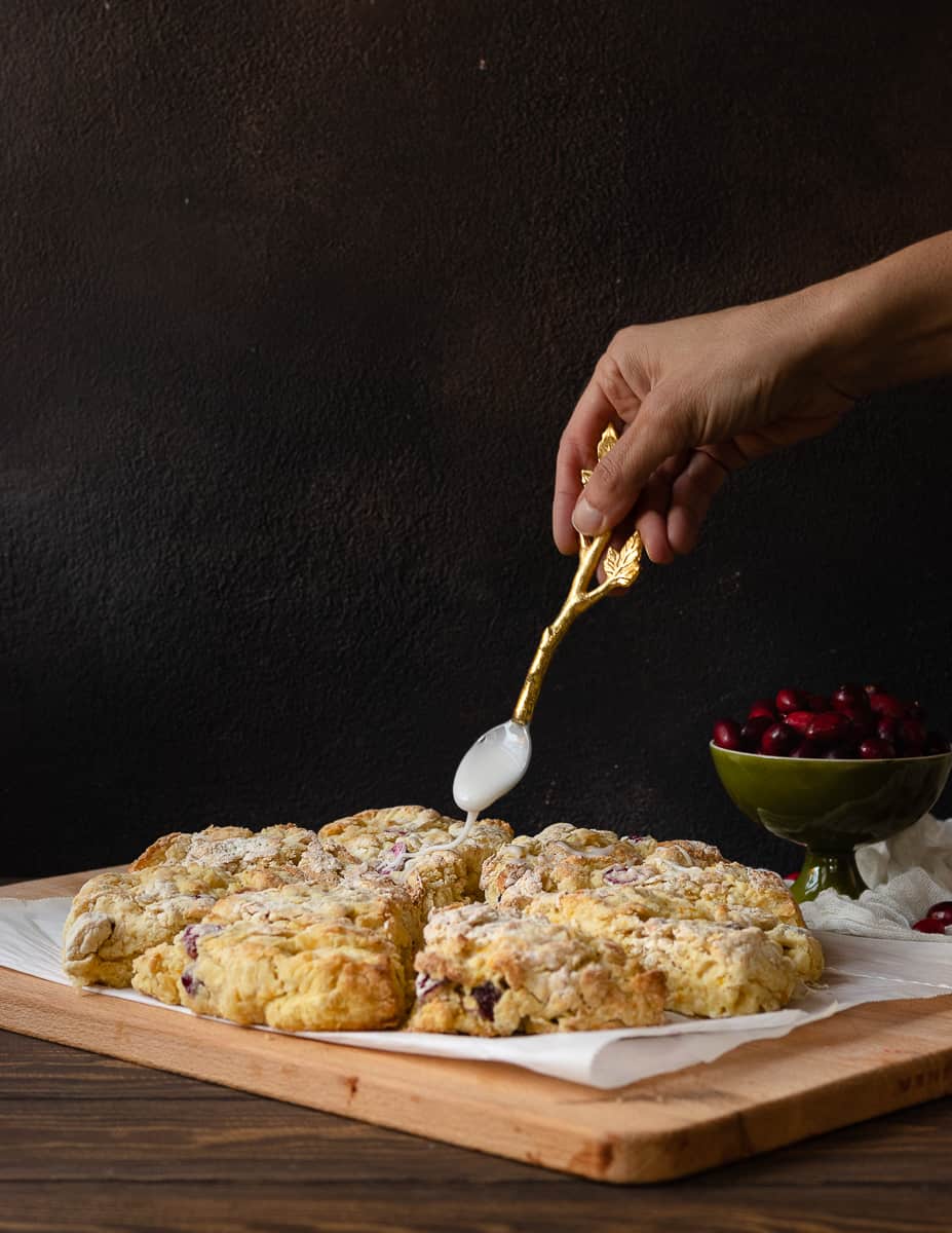 Keep winter breakfast bright with these flavorful fresh cranberry orange scones! Make the dough ahead and freeze, or mix and bake in under an hour. This easy buttermilk scone recipe is a great way to use fresh cranberries! * Recipe on GoodieGodmother.com