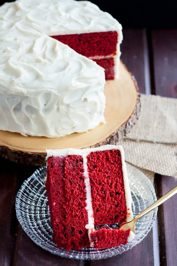 image of red velvet cake slice on a plate with a gold fork