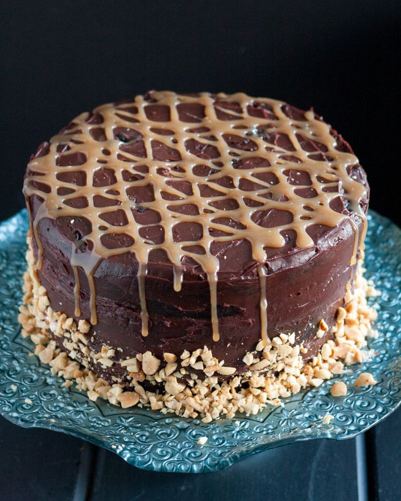 Rich chocolate cake, layers of homemade nougat, peanuts, and caramel, all covered with a rich ganache - candy bar dreams come to life! Recipe on GoodieGodmother.com
