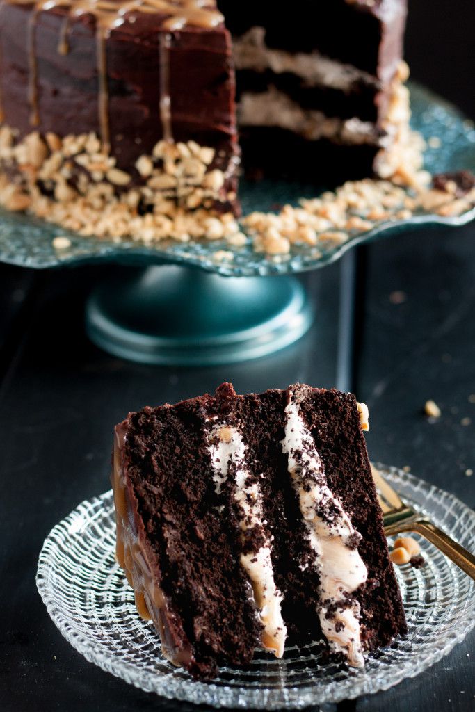 Rich chocolate cake, layers of homemade nougat, peanuts, and caramel, all covered with a rich ganache - candy bar dreams come to life! Recipe on GoodieGodmother.com
