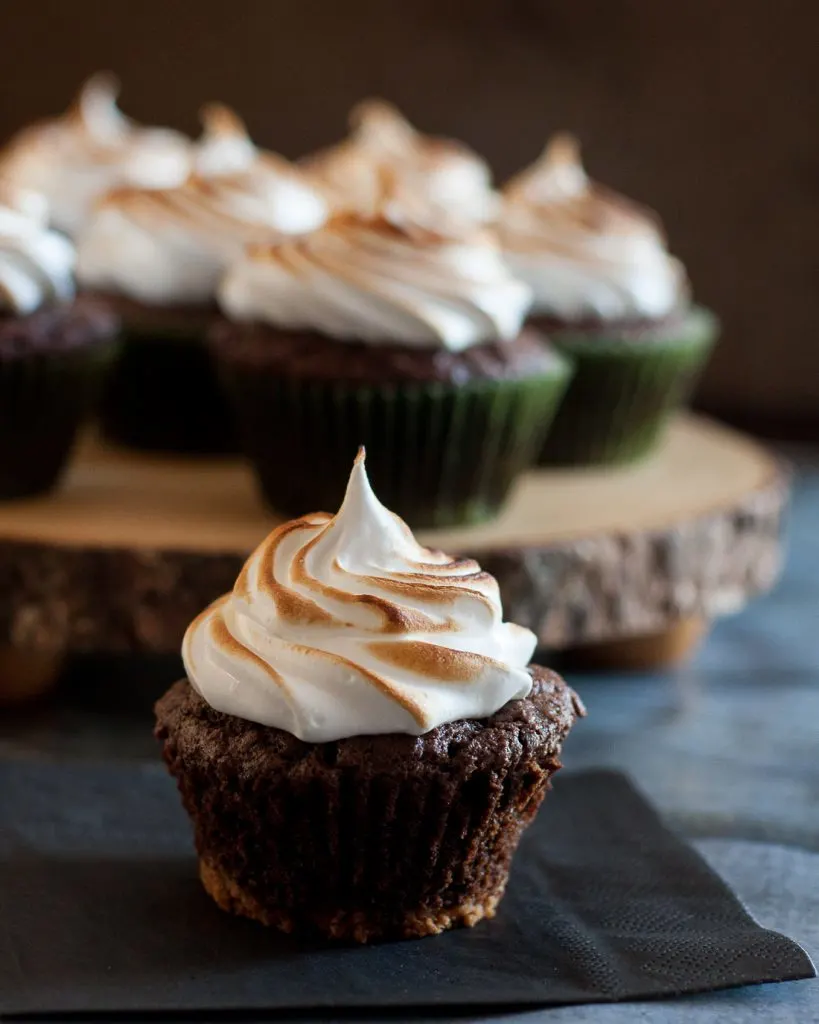Caramel stuffed s'mores cupcakes... yes, please! This s'mores cupcake recipe has all the flavors of everyone's favorite fireside treat with an extra delicious surprise inside. * Recipe on GoodieGodmother.com