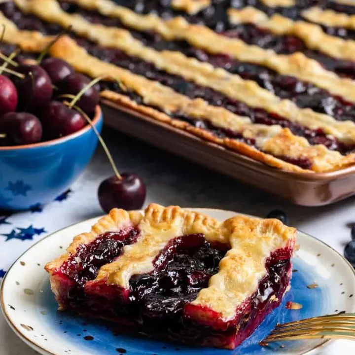 This patriotic blueberry cherry slab pie is a festive way to celebrate summer. Even pie newbies will achieve beautiful results with the easy to follow video tutorial! * Recipe on GoodieGodmother.com #4thofjuly #patrioticdessert #redwhiteandblue #slabpie #cherrypie #summerdessert