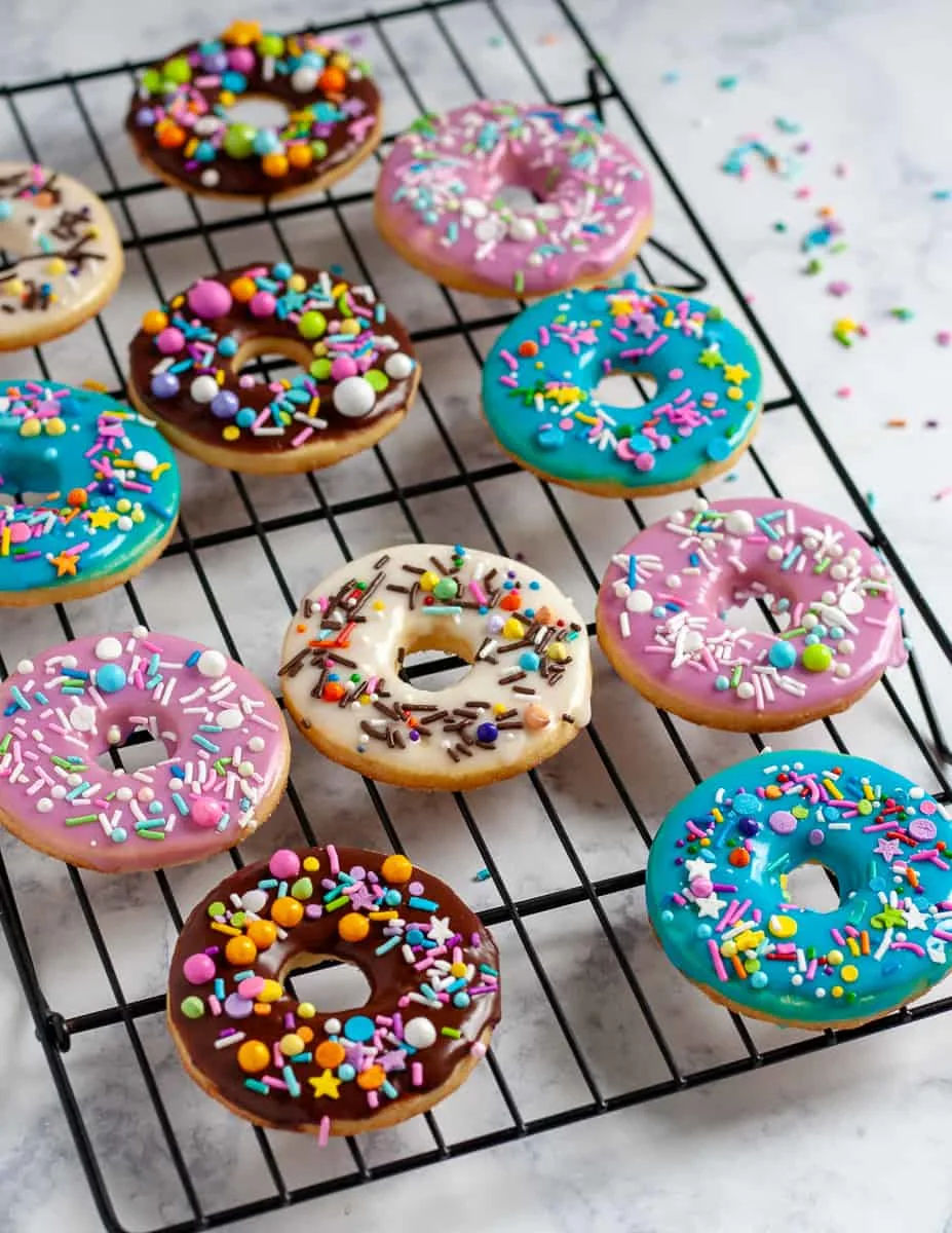 Whip up a batch of colorful iced sugar cookies in no time with this doughnut sugar cookie tutorial and easy cookie glaze recipe! It's so easy to make these colorful cookies - even if you've never decorated a sugar cookie before. * GoodieGodmother.com