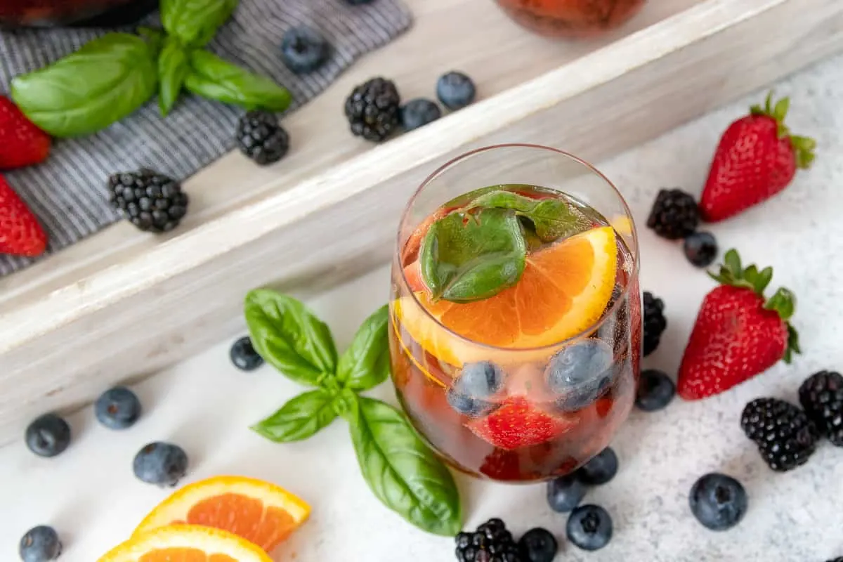 Summer's favorite wine shines with berries in this mixed berry basil rosé sangria recipe! - Showcasing the beautiful fruit in glass