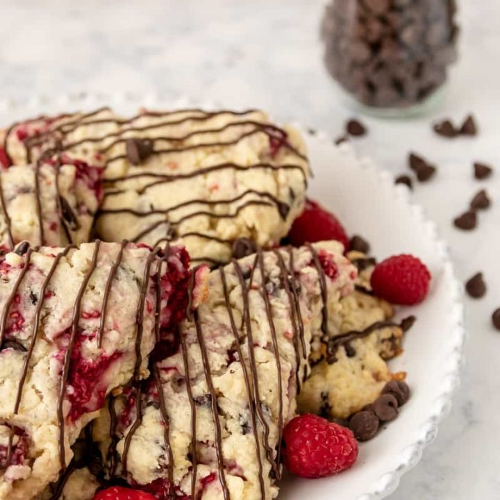 Fresh raspberry chocolate chip scones are a delicious treat to make for breakfast, brunch, or tea! Freezer friendly, and you can use fresh or frozen fruit in this easy scone recipe. * Recipe on GoodieGodmother.com #breakfastideas #bakingrecipes #scones #brunchfood #dessertrecipes #freezerfriendly #makeahead