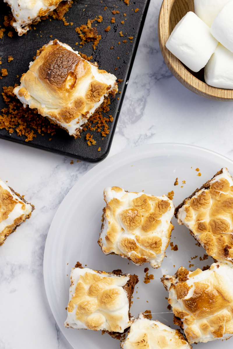 overhead shot of s'mores brownies on a white plate with a white background