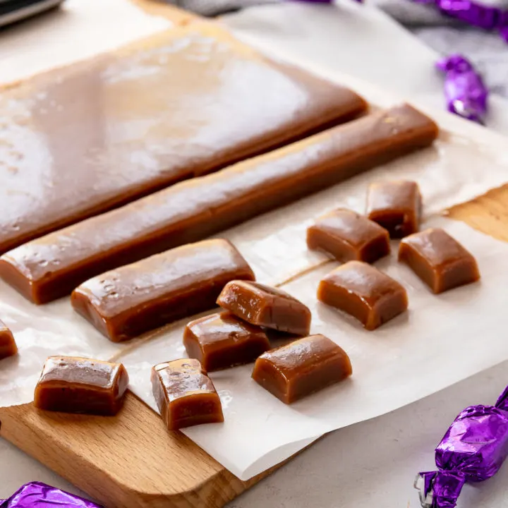 chai tea caramels on a cutting board. some are wrapped, others are not
