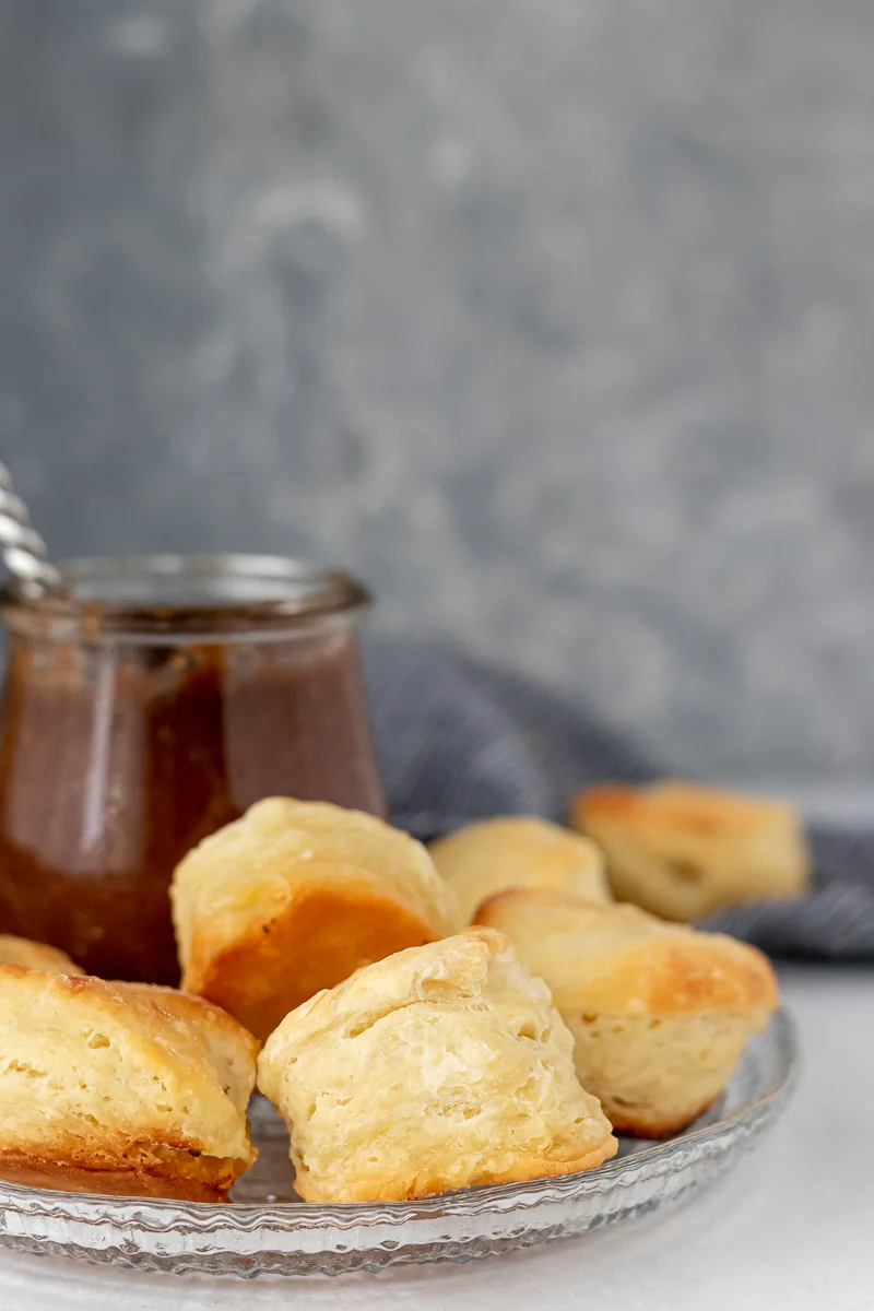 flaky homemade biscuits on a plate with apple butter (serving suggestion)