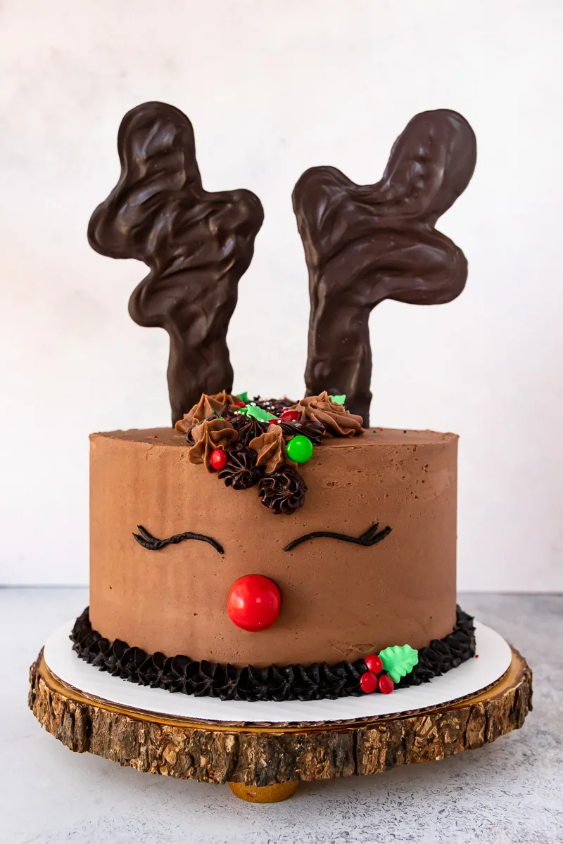 front view of the reindeer cake on a wooden cake board with a white background