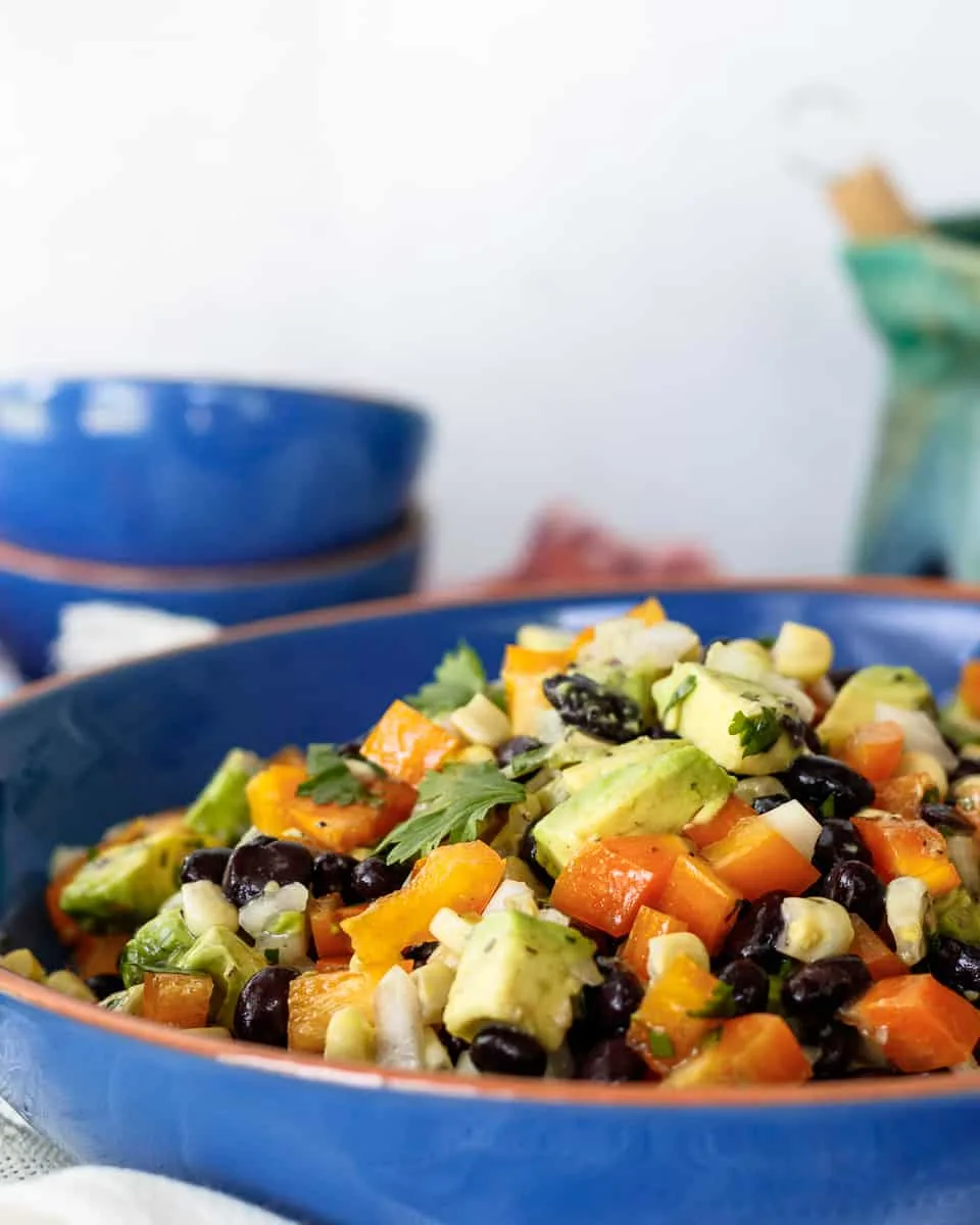 close up of the corn and black bean salad in a blue serving bowl