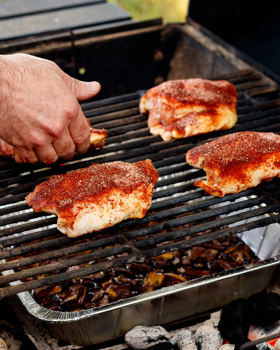 chicken thighs being placed on the grill
