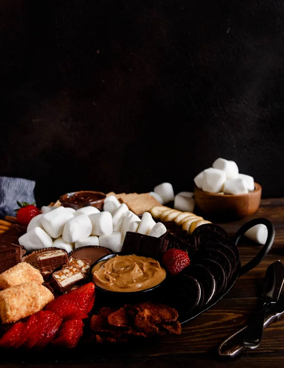 smores board on a wooden table with a black background