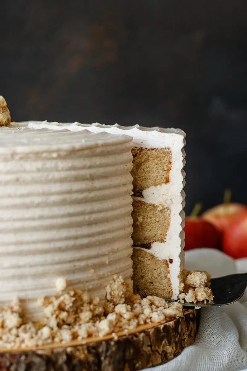 close up of the cinnamon swiss meringue buttercream on the brown sugar layer cake. Highlights the details in the crumb topping and shows a closeup for a decorating option using a cake comb.