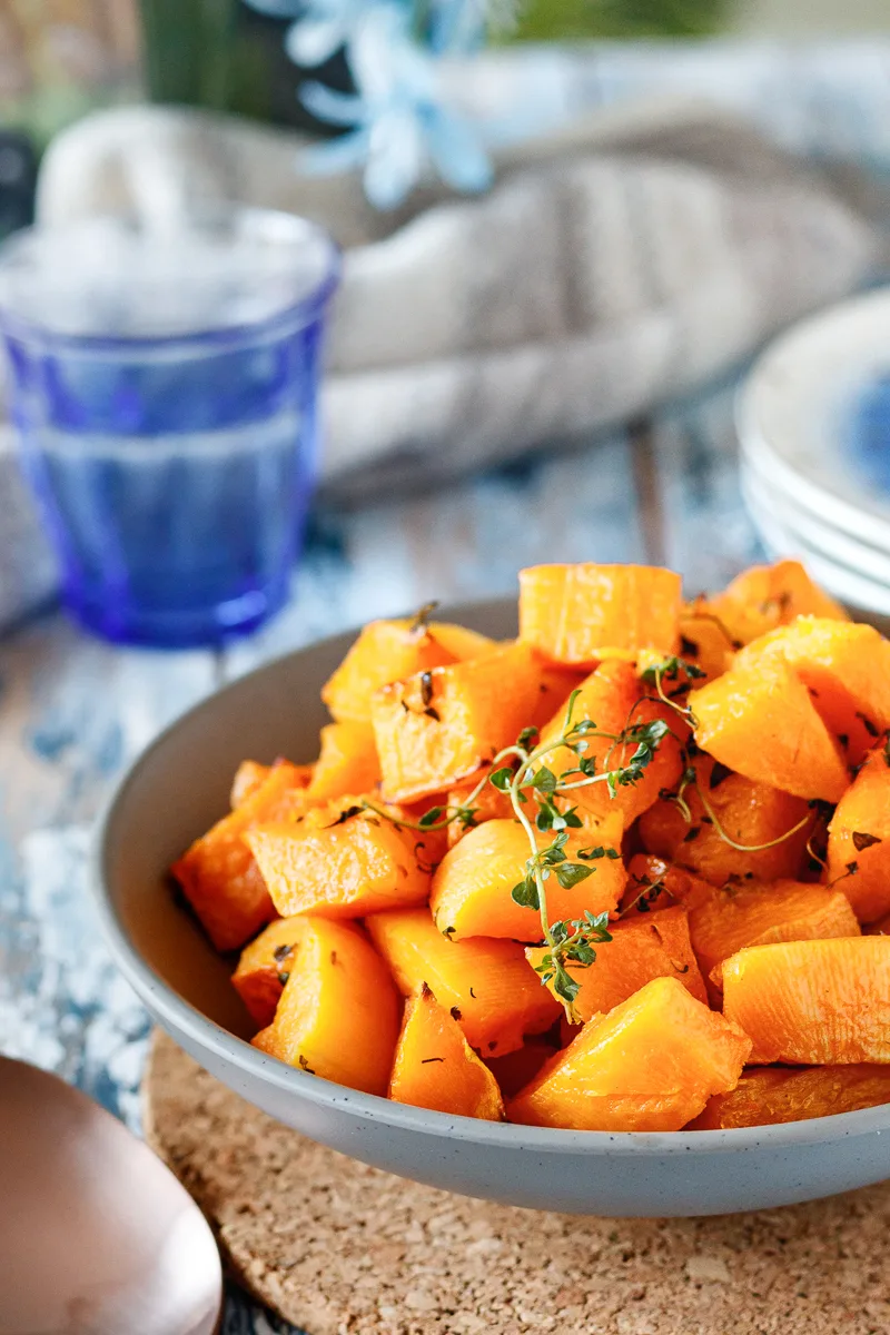 lemon thyme roasted butternut squash ready to serve in a grey bowl