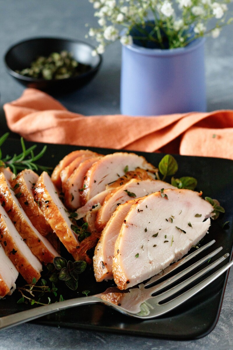 angled picture of sliced smoked turkey breast with a serving fork