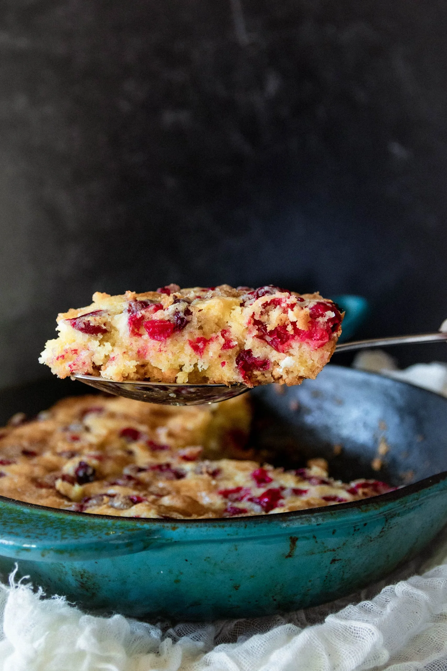 wedge of cranberry skillet cake closer to the camera to show texture