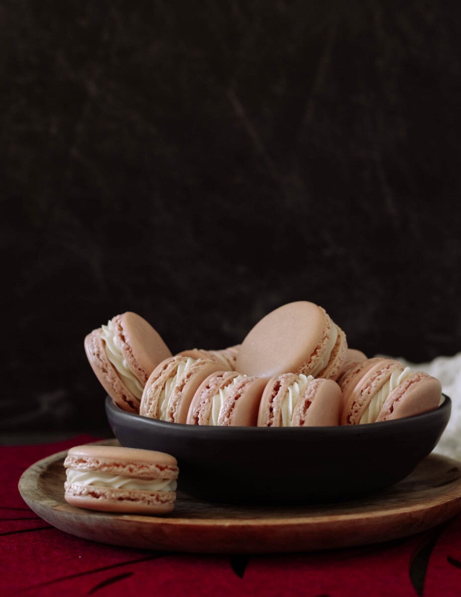 maple macarons on a wooden plate and dark shallow bowl. dark background