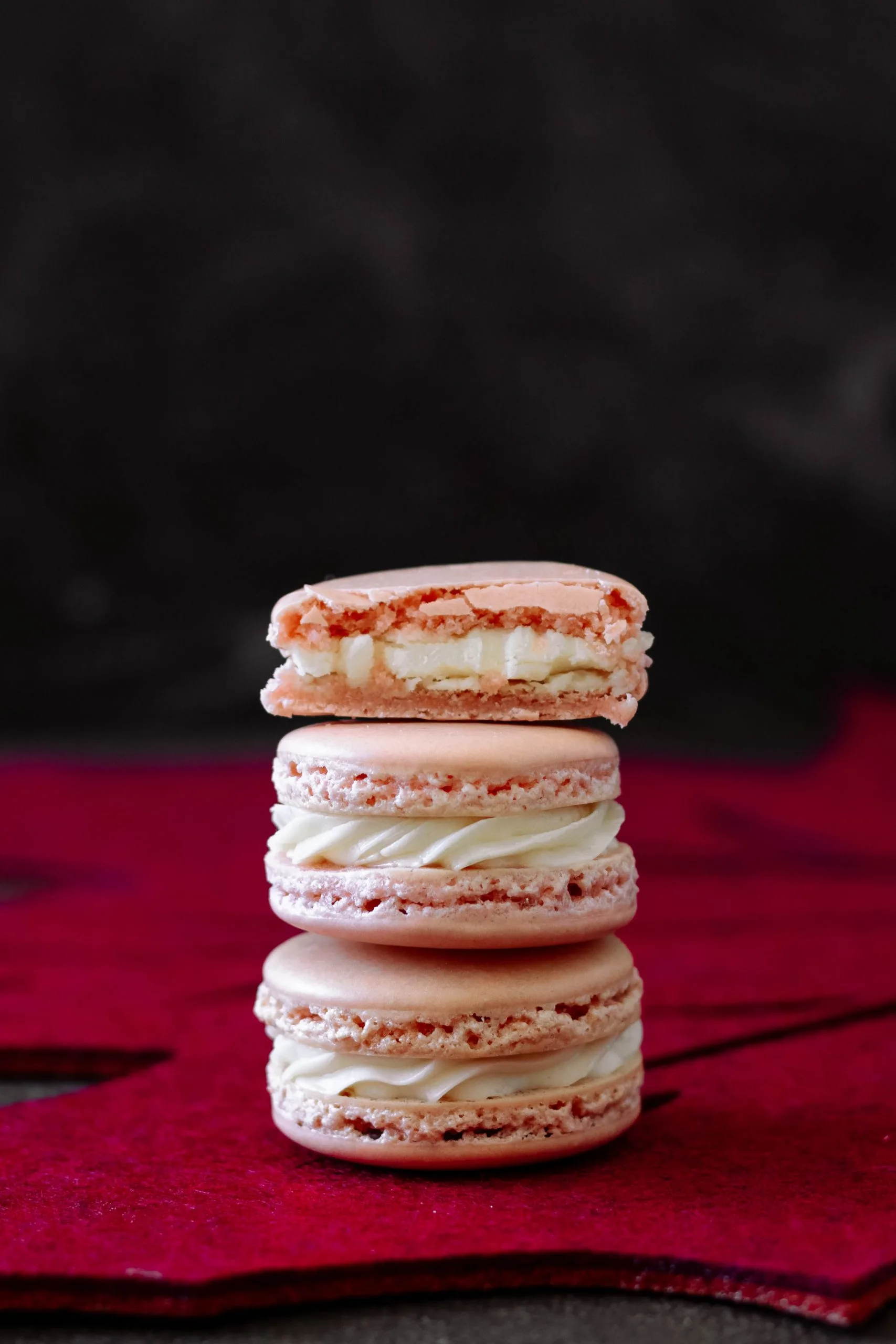 stack of three maple macarons with the top macaron cut in half to show the filling