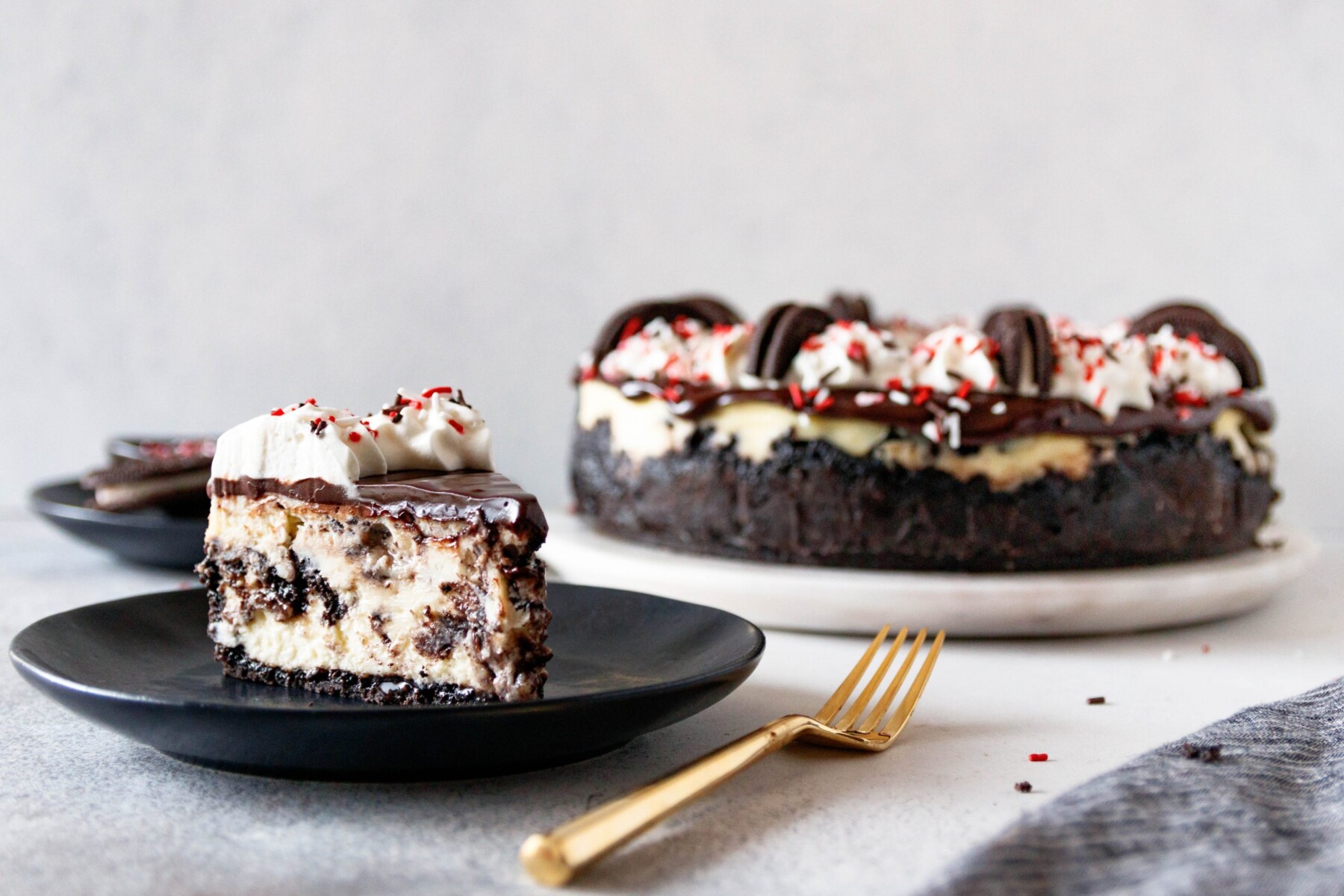horizontal picture of a slice of peppermint oreo cheesecake with a gold fork