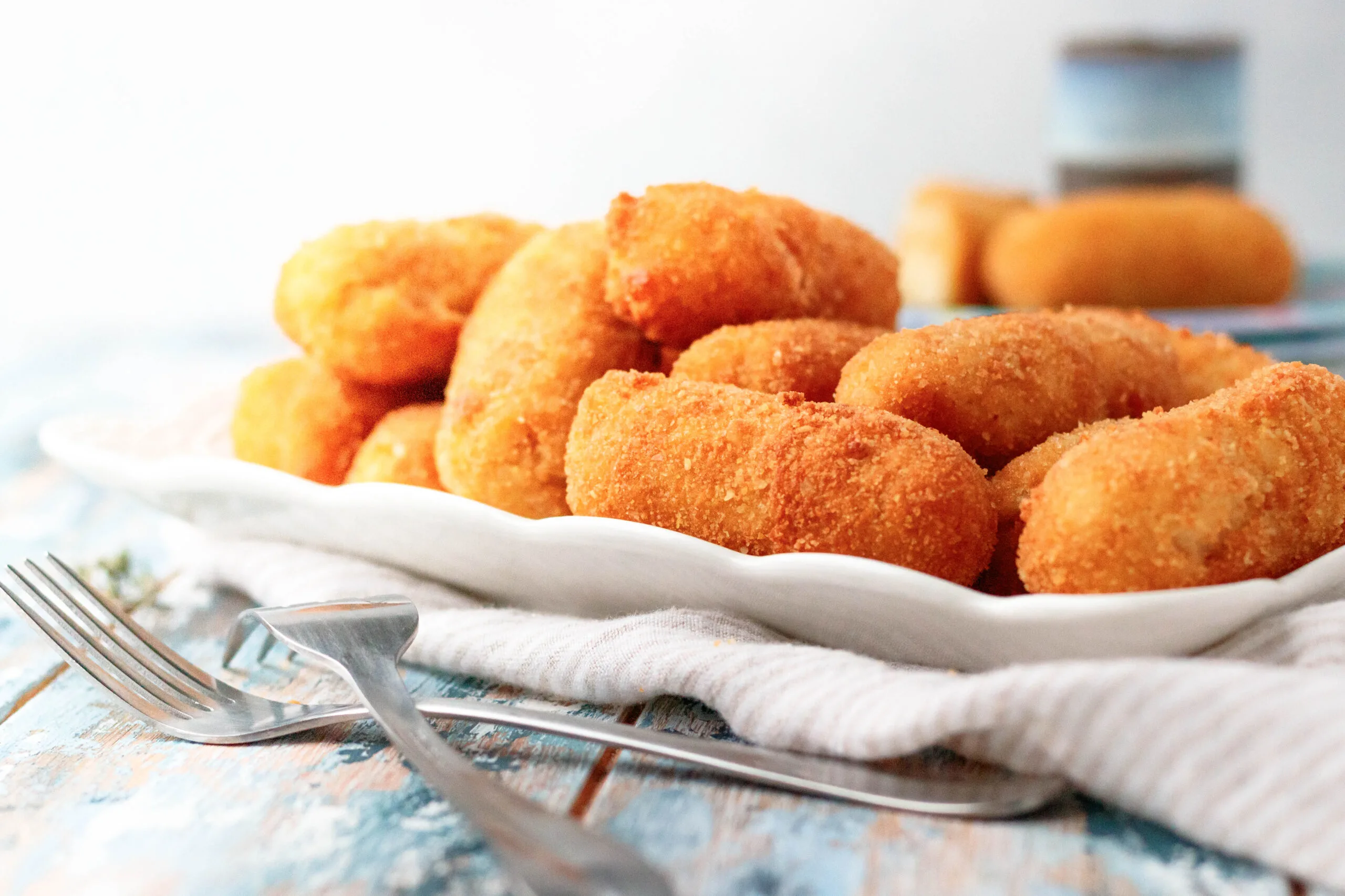 chicken croquettes piles on a white rectangle serving plate ready to enjoy!