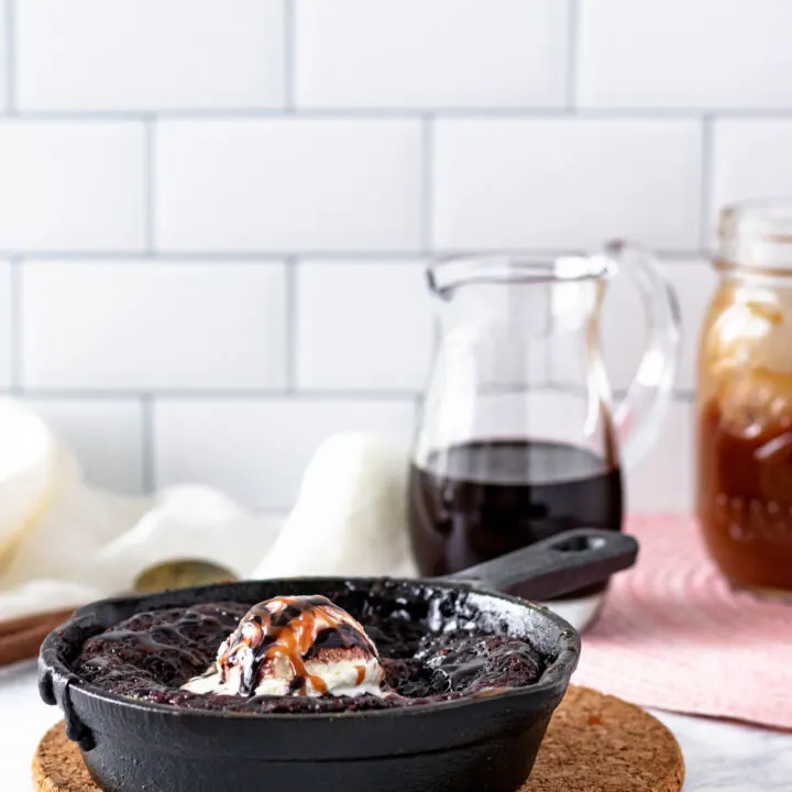 hot fudge cake sitting on a cork trivet with a white subway tile background