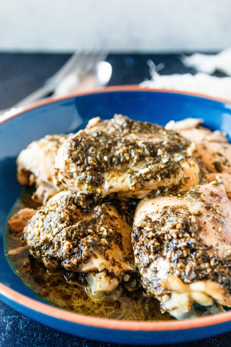angled view of the slow cooker ranch pesto chicken in a large blue bowl ready to serve - this time made with boneless skinless chicken thighs, not shredded