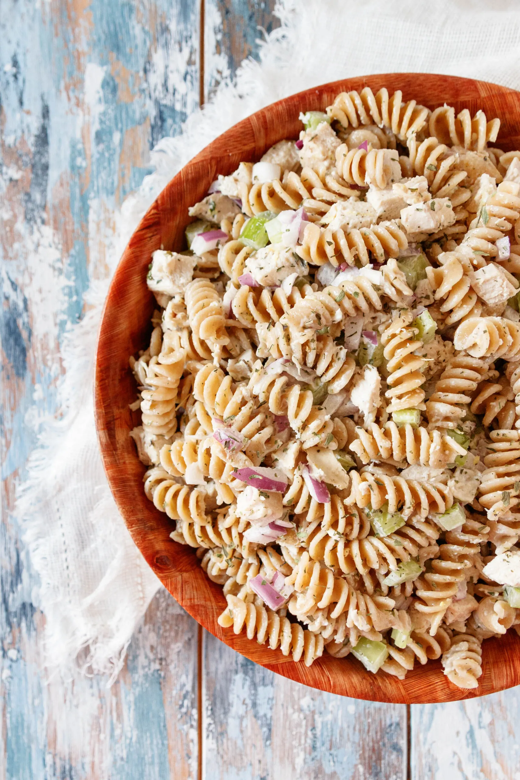 top view of the whole wheat pasta salad on a mottled blue background