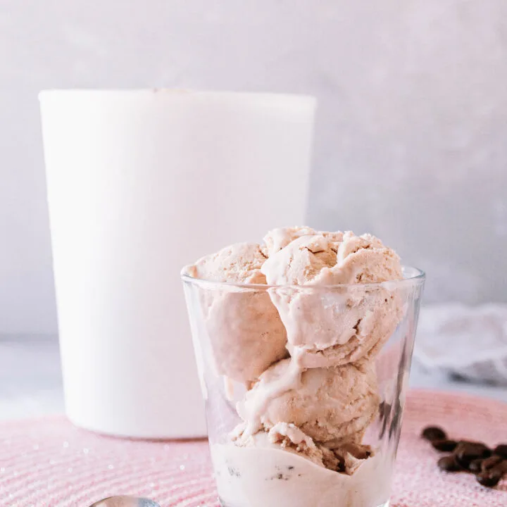 no churn coffee ice cream served in a glass cup with the larger ice cream container in the background