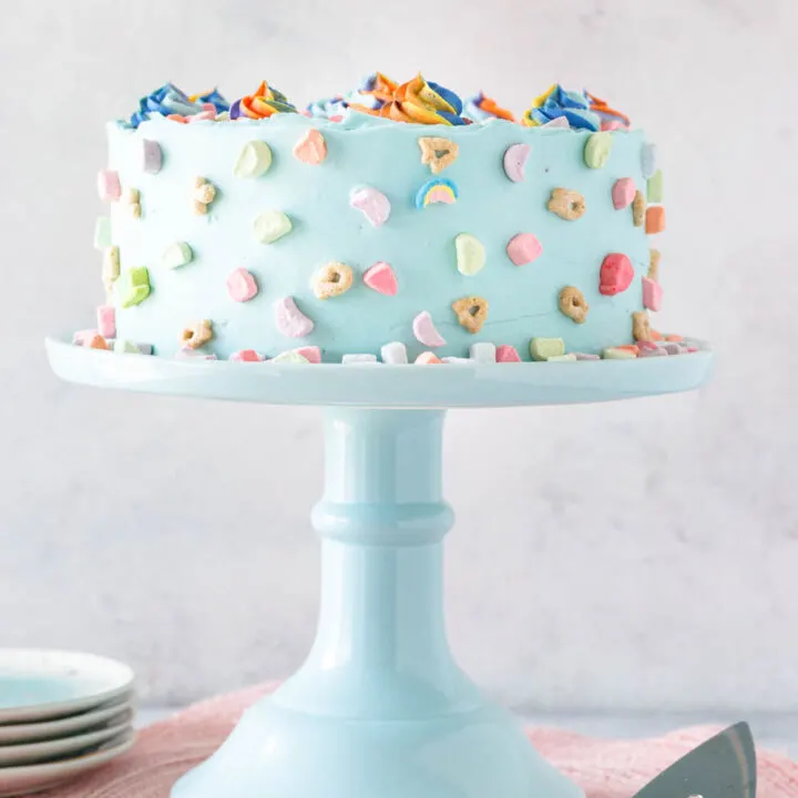 decorated cereal milk cake on a tall pale blue cake plate