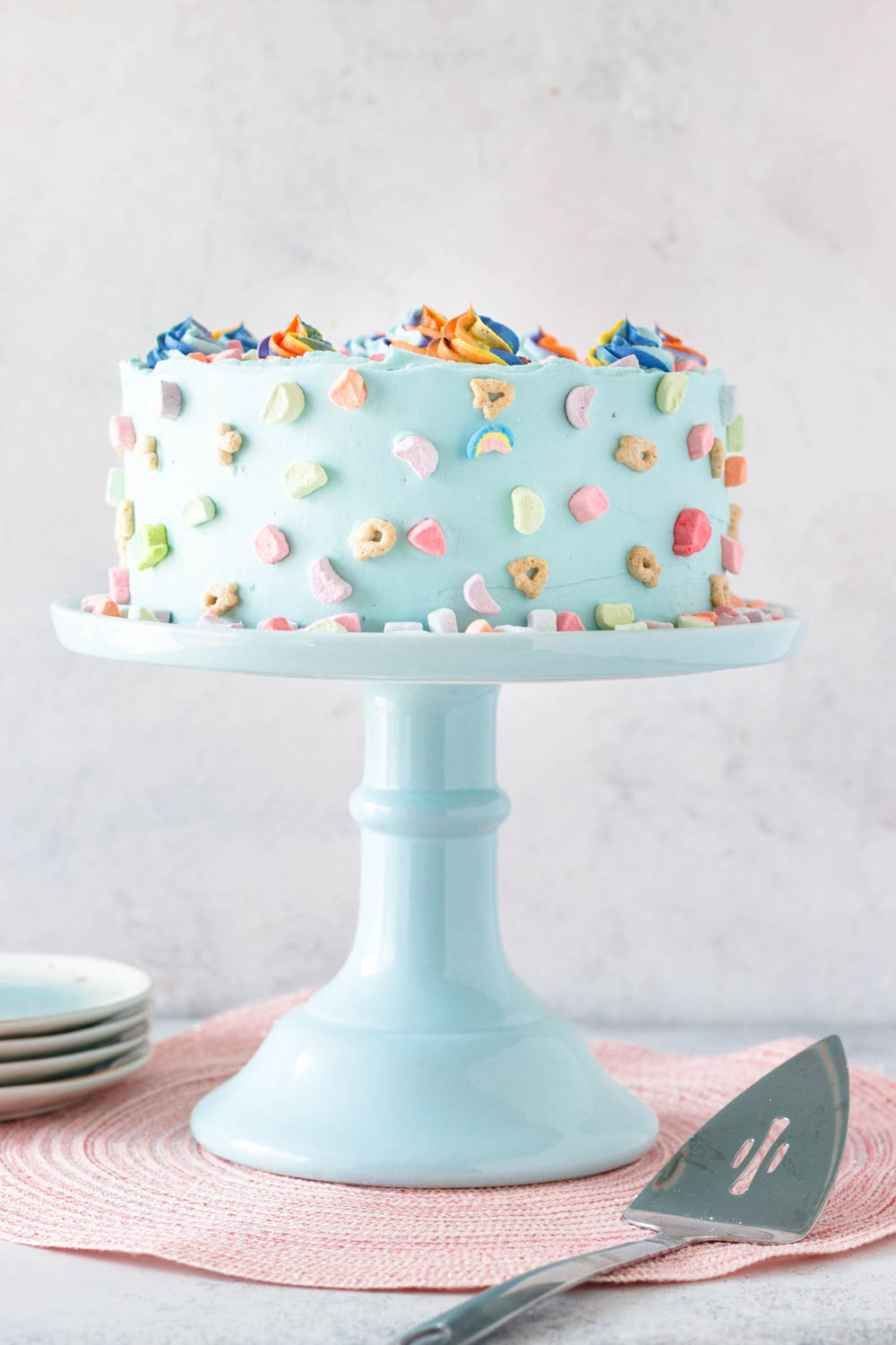 decorated cereal milk cake on a tall pale blue cake plate