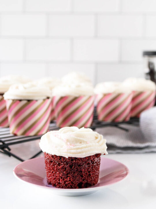 vegan red velvet cupcake on a pink saucer, ready to enjoy!