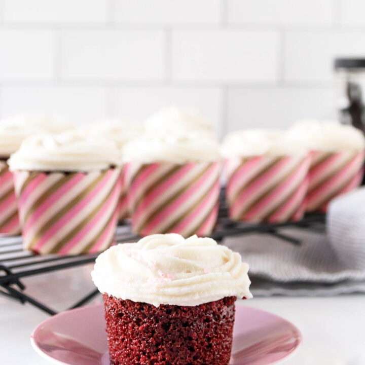 vegan red velvet cupcake on a pink saucer, ready to enjoy!