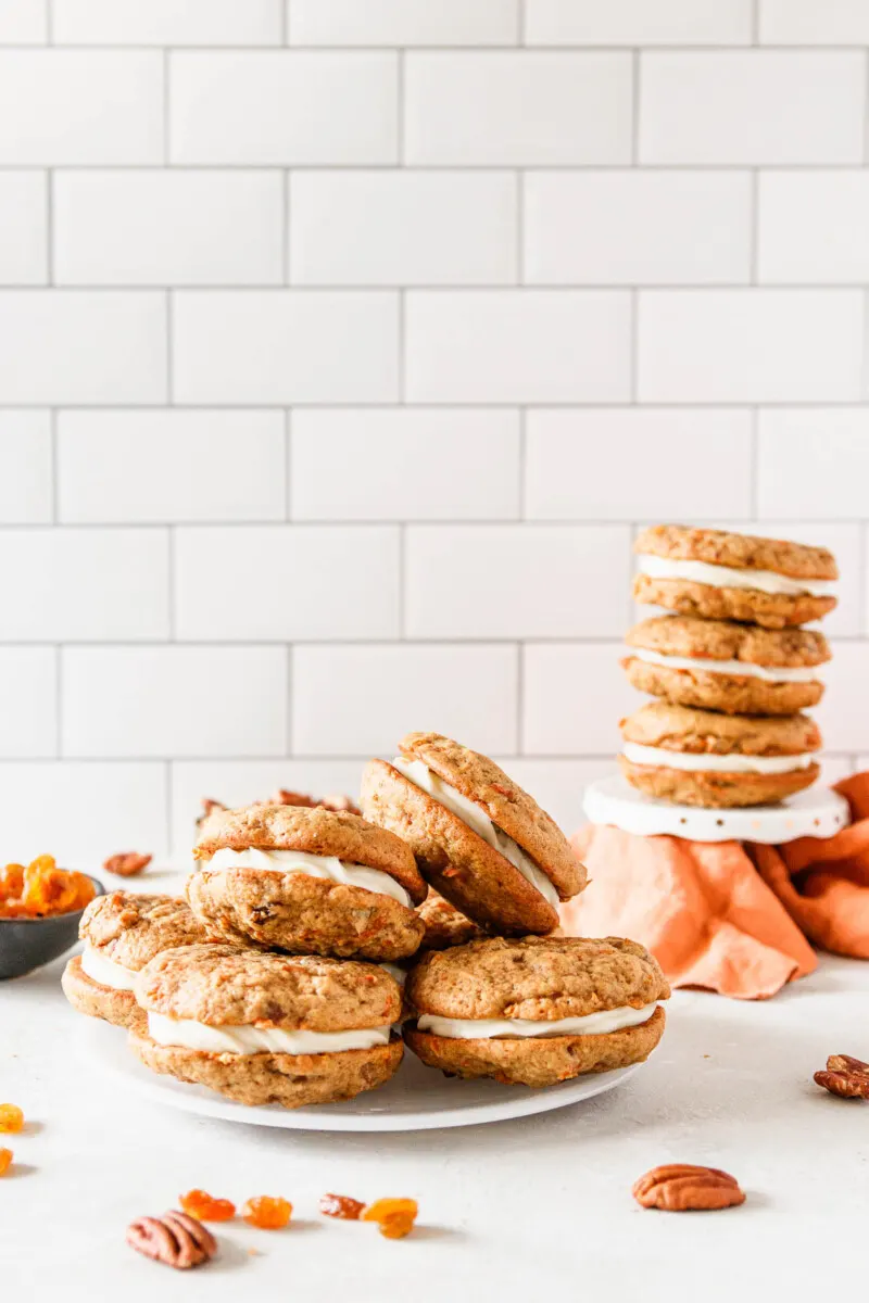 https://goodiegodmother.com/wp-content/uploads/2022/04/carrot-cake-sandwich-cookies-on-a-plate-and-stacked.jpg.webp
