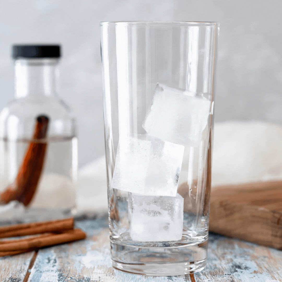 animated gif of cold brew coffee being poured over ice in a clear highball glass.