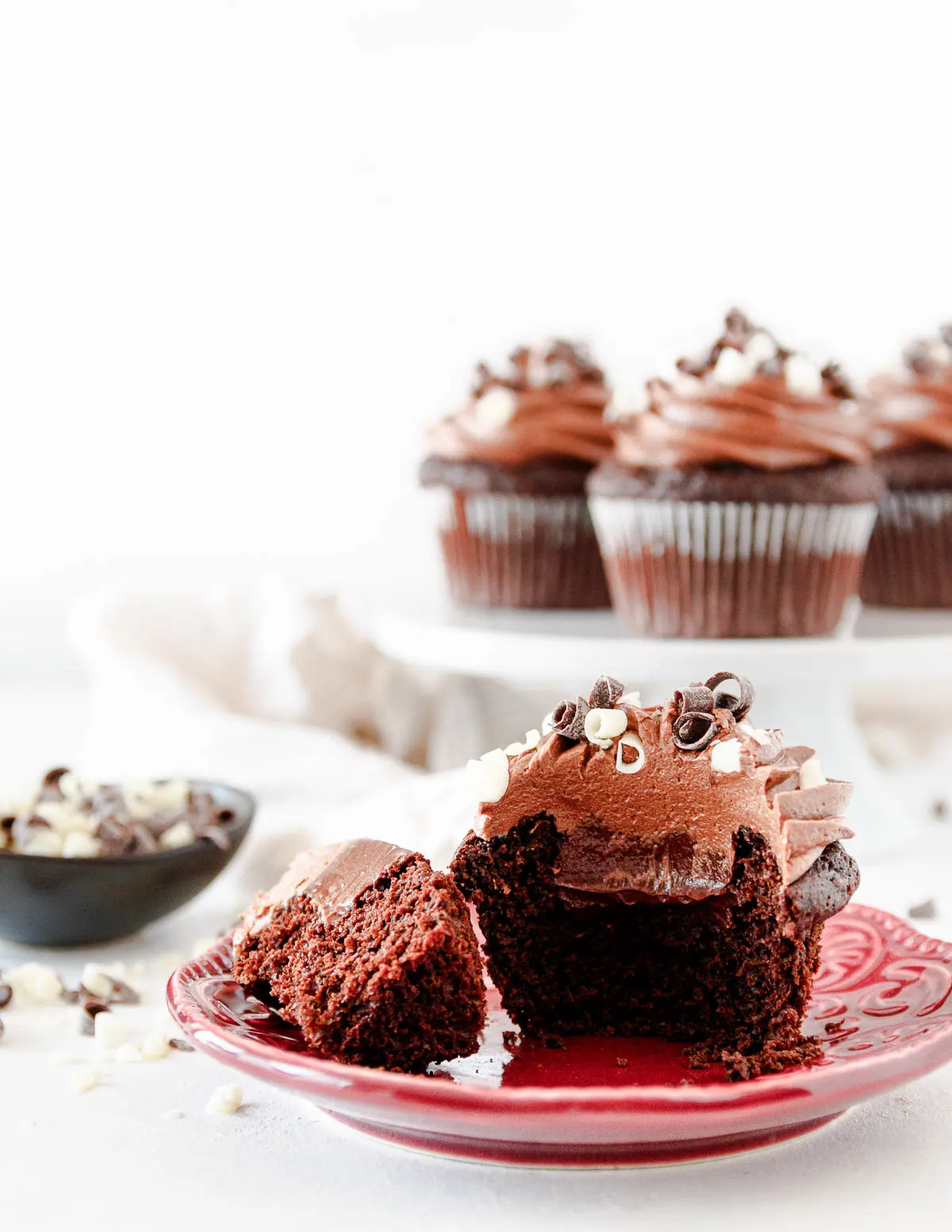 Decorated triple chocolate cupcake on a plate and cut open to show the 3 layers of chocolate