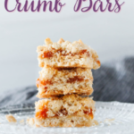three stacked peach crumb bars on a glass plate with text overlay on the photo