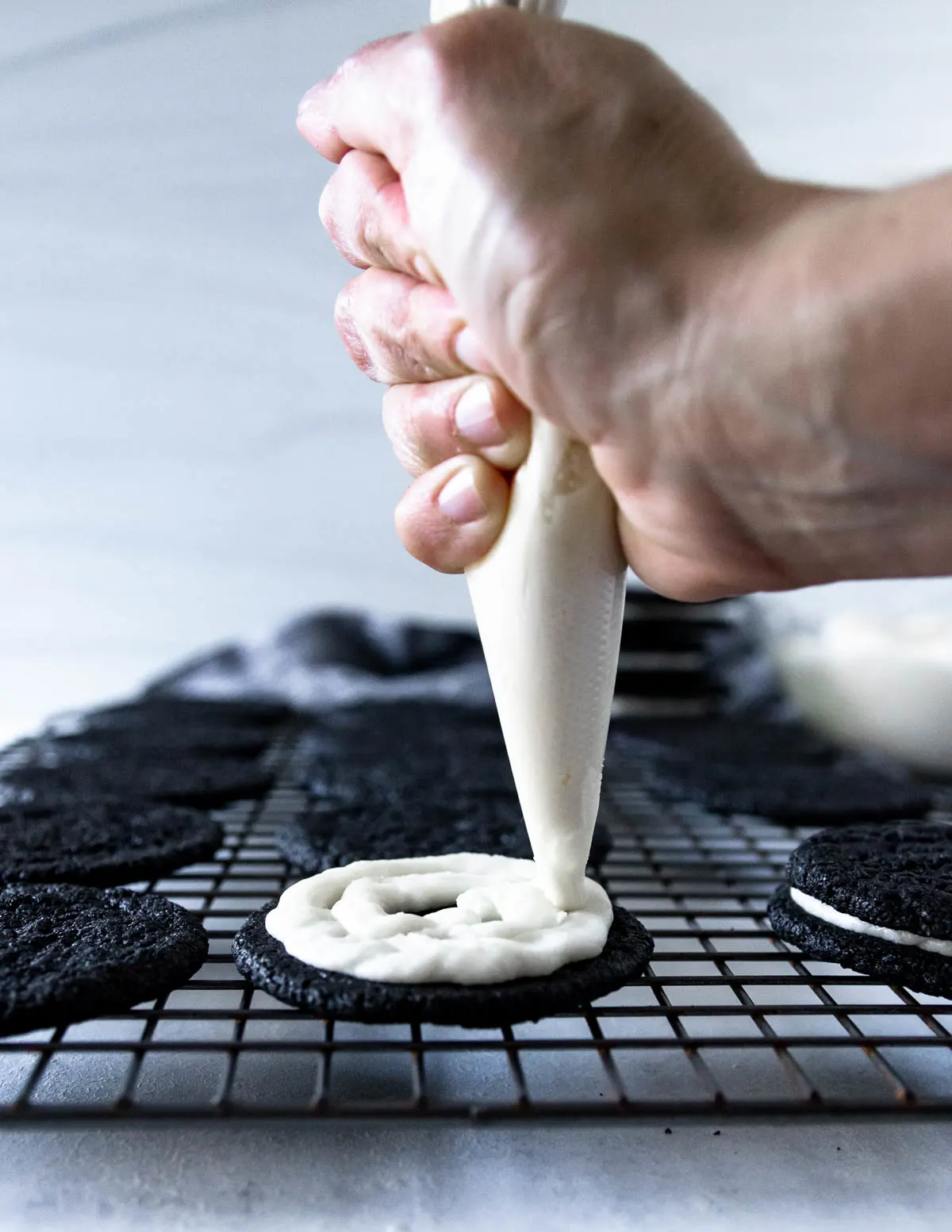 hand piping creme filling onto a cookie